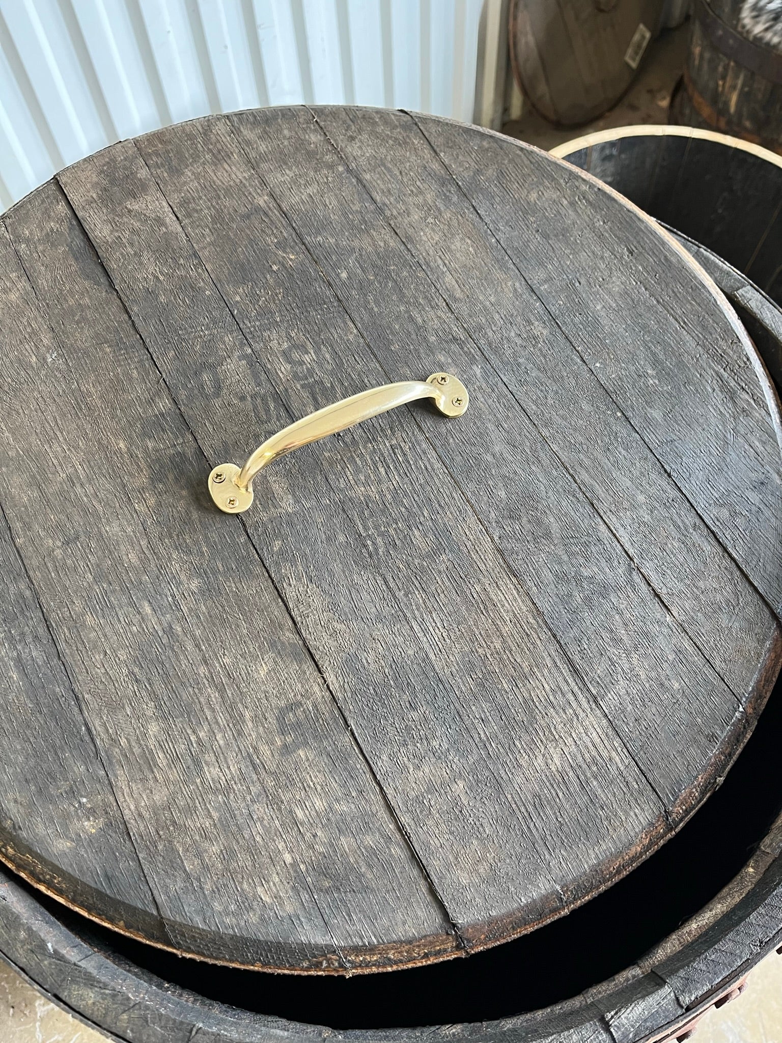 detalj på lock och handtag i mässing på Bourbon and scotch cask, whiskytunna med lock, 190L, ca 88 cm höjd, rustikt utseende med rostiga tunnband, massiv ek.